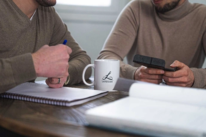 Réunion d'équipe autour d’une pièce en matériaux composites et d'un goodies Lavoisier Composites