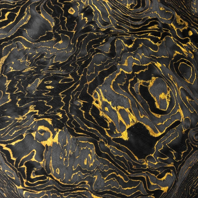 Texture détaillée du veinage d'un matériau composite en fibre de carbone avec des particules dorés - Carbonium® Gold