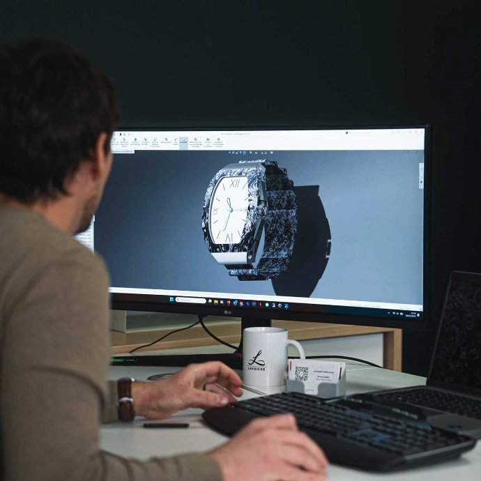 Expert en bureau d'études réalisant sur un ordinateur la modélisation 3D d'une montre de luxe en matériaux composites